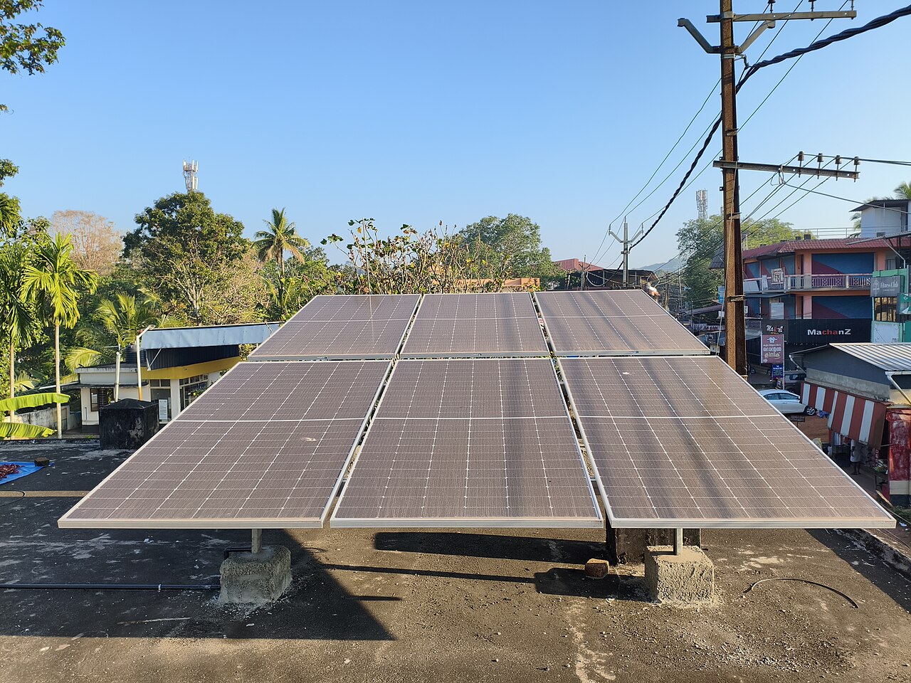A rooftop solar array next to a power line