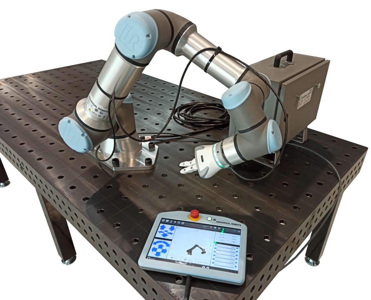 A collaborative robot arm mounted on a steel welding table with its control pendant